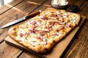 Flammkuchen met roomkaas, bacon en rode uien