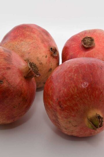 4 gezonde granaatappels op een witte achtergrond.